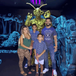 A family poses in front of an alien while spending time at Twilight Zone Mini Golf.